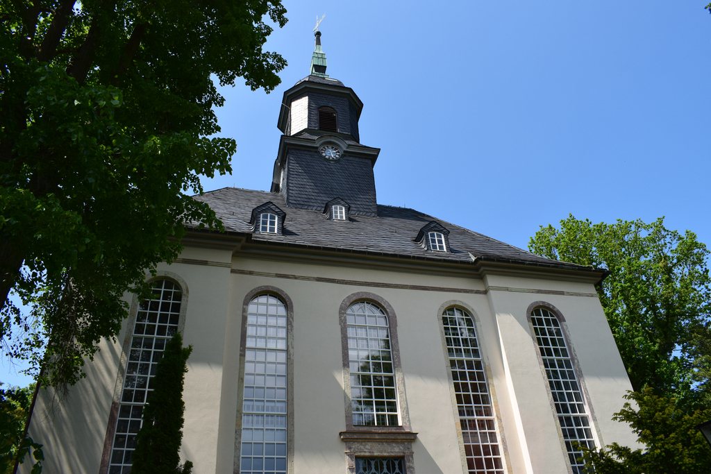 Die Kirche von Gornsdorf von unten nach oben fotografiert vor einem leuchtend blauem Himmel.